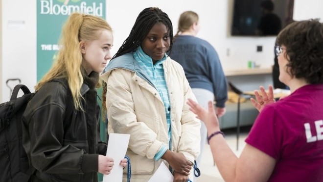 students talking to a department at the on campus job fair